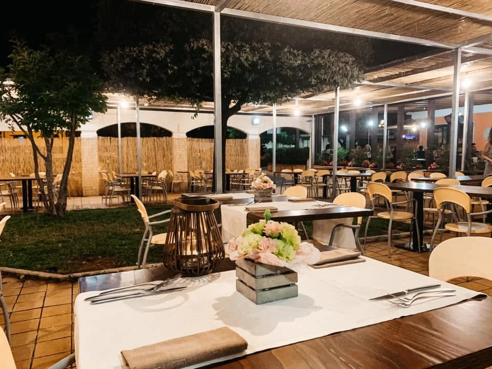 La terrazza esterna de La Piazzetta illuminata di sera